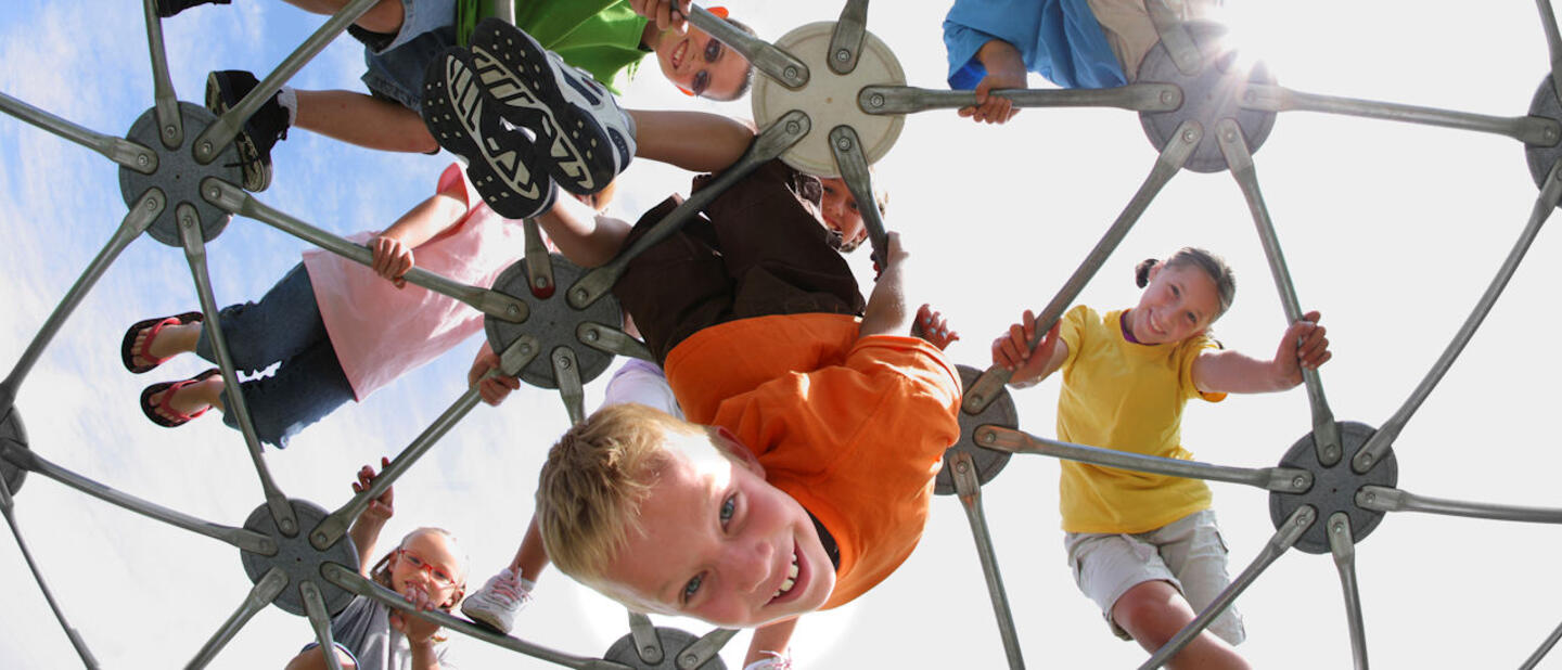 Kinderen hangen op hun kop in klimrek