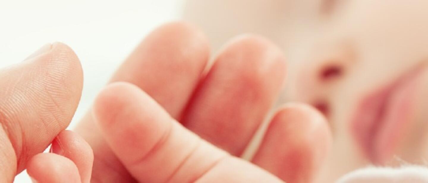Slapende baby met moederhand