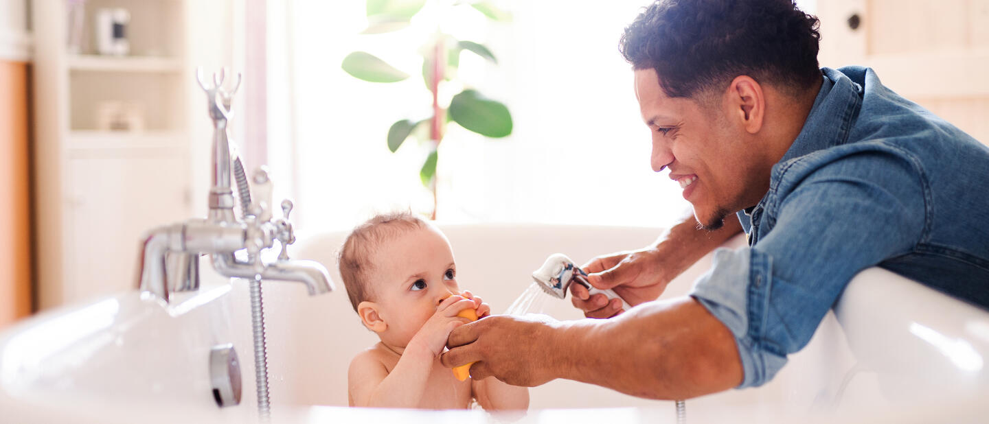 Baby in bad met vader erbij