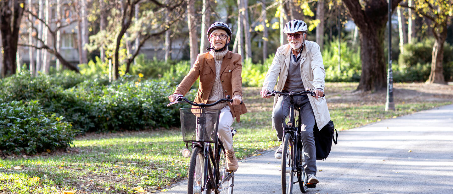 Oudere fietsers in het park met fietshelm