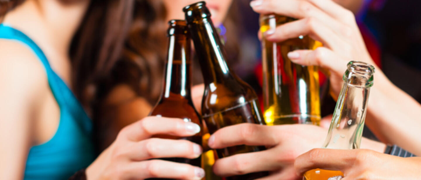 Borrelende mensen met bierflesjes in de hand
