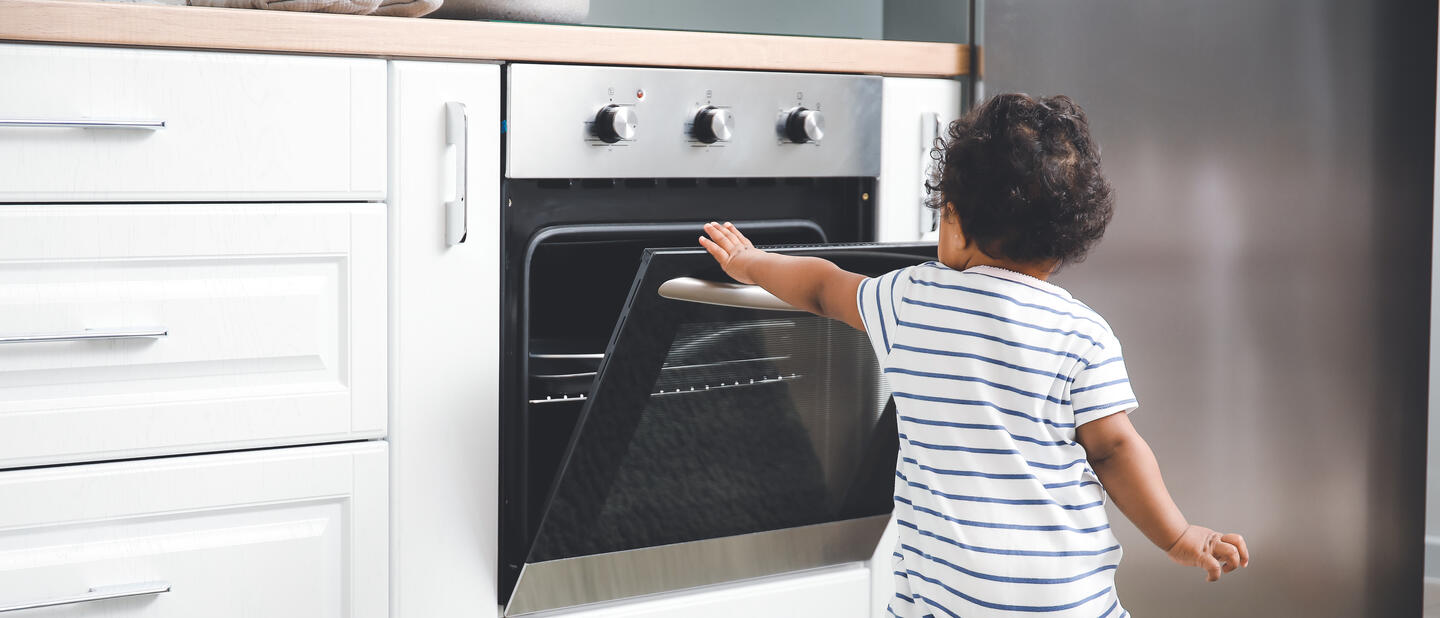 Baby in keuken bij de oven
