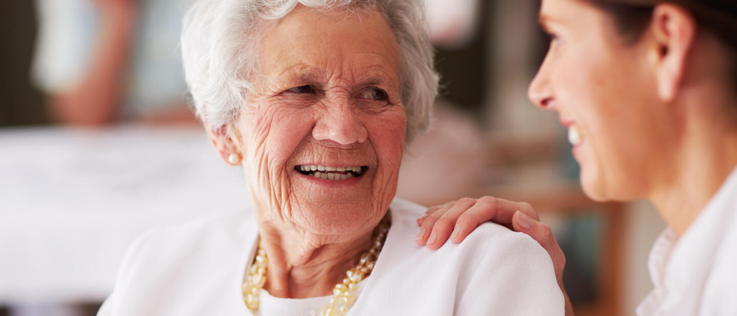 lieve oudere dame in gesprek met zorgverlener