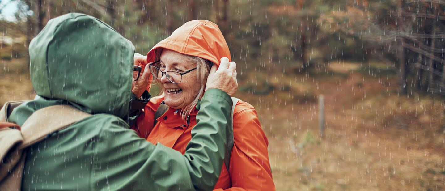 oudere dame oranje jas in regen