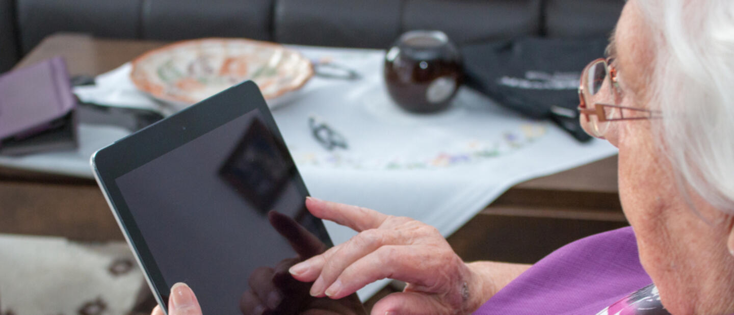 oudere dame paars shirt met ipad