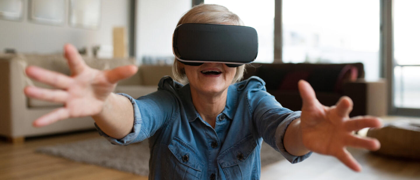 oudere dame met vr bril handen vooruit