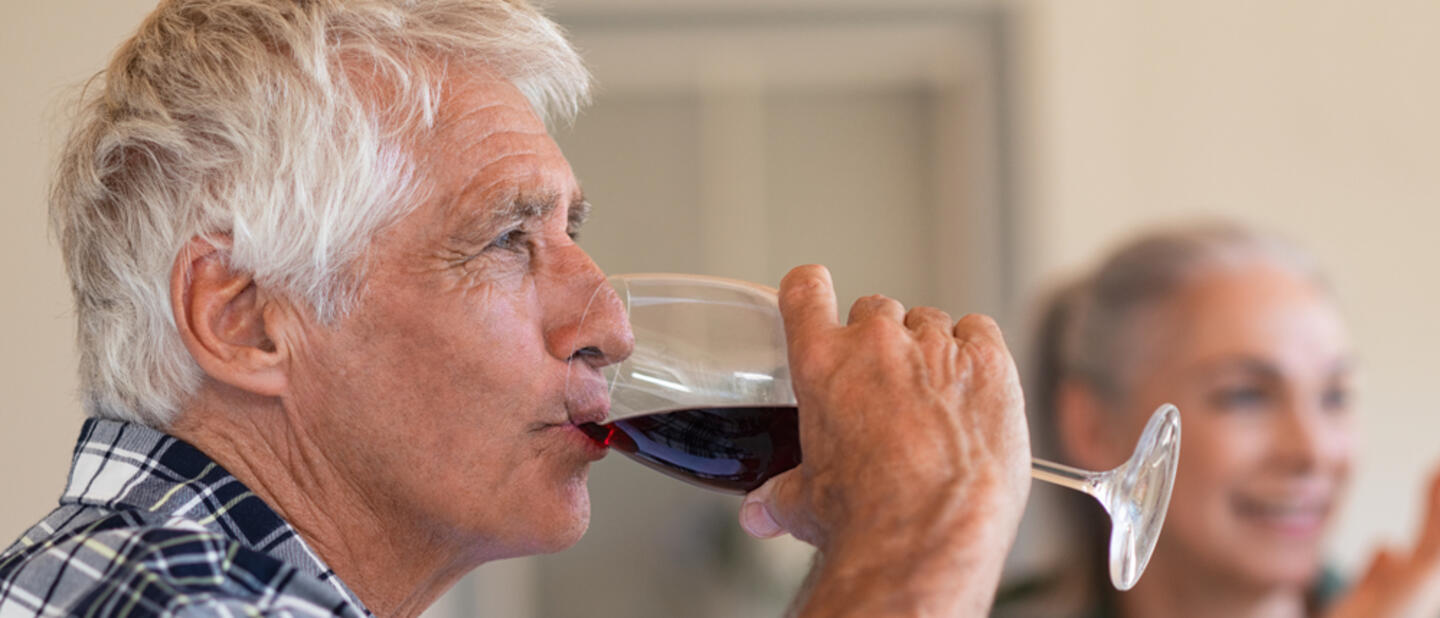 Oude man drinkt rode wijn