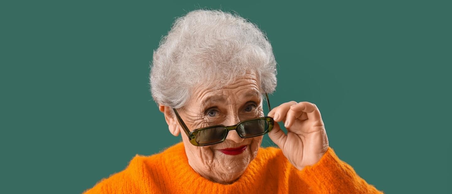 blije oudere dame met oranje trui