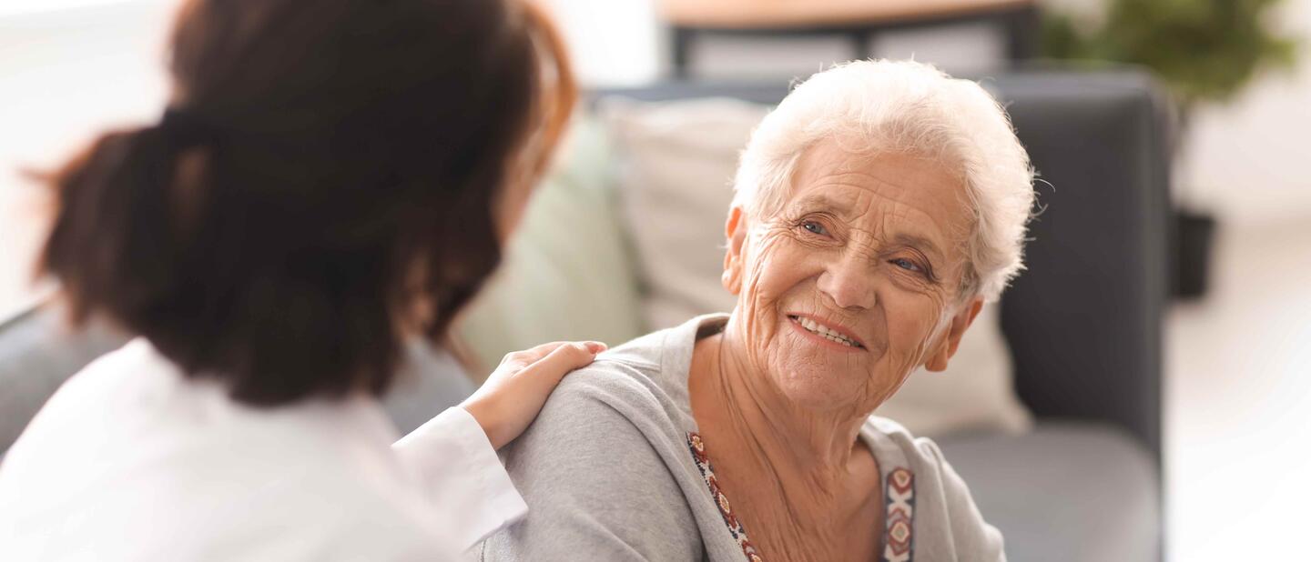 oudere dame in gesprek met zorgprofessional