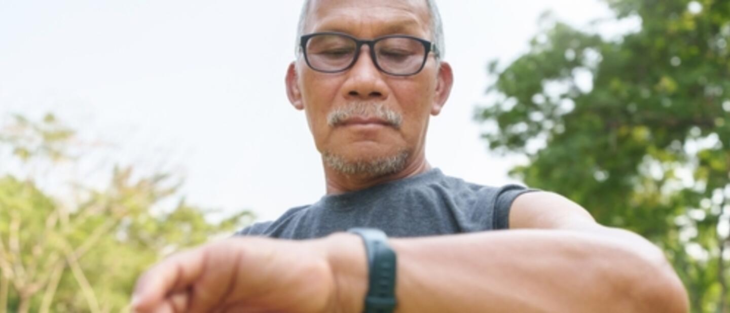 oudere man kijkt op smart watch